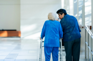 Personne âgées qui est accompagnée par une aide soignante